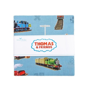 May include: A stack of square fabric pieces featuring a light blue background with illustrations of Thomas the Tank Engine and his friends. The fabric has images of trains, railroad tracks, and signs. The words "Thomas & Friends" are printed on a white band.