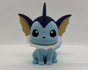 May include: A light blue figurine of a cartoon creature with large black eyes, a white ruffled collar, and tan fins. The figurine has a dark blue head and a fin on top. The creature is in a sitting position.