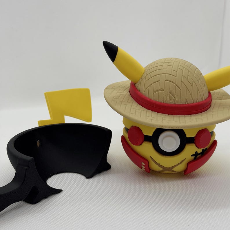 May include: A yellow Pikachu figure wearing a straw hat with a red band and black-rimmed glasses. The figure has red cheeks and a black lightning bolt tail. A black stand and a yellow lightning bolt are also present.