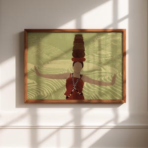 Puede incluir: Una impresión artística enmarcada que presenta una ilustración estilizada de una persona con un vestido rojo equilibrando ollas marrones apiladas sobre su cabeza. El fondo tiene un patrón verde y beige, y el marco es marrón.