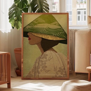 May include: A framed art print depicting a woman in profile, wearing a large, green and yellow hat. The artwork has a vintage style, with a soft colour palette of greens, yellows, and beige. The woman is wearing a floral patterned dress.