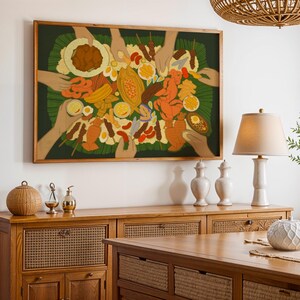 May include: A framed artwork depicting a colorful array of food items, including fruits, meats, and sauces, arranged on a green leaf. The artwork features multiple hands reaching towards the food. The frame is a warm brown color, and the artwork is displayed on a white wall.