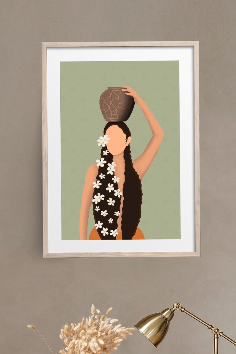 May include: Art print of a woman with long dark hair, adorned with white flowers, carrying a brown pot on her head. The artwork is set against a light green background with a subtle pattern, framed in a light wood frame.