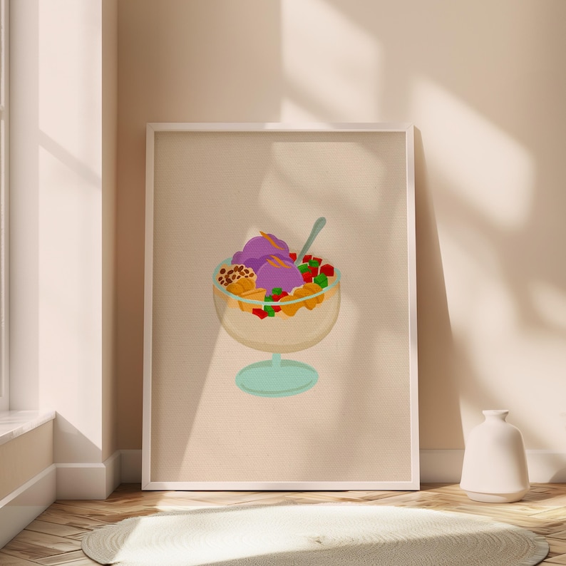 May include: A framed print featuring a colorful illustration of a Filipino halo-halo dessert. The dessert is in a clear glass with purple ice cream, fruit, and other toppings. The frame is white, and the background is a neutral beige.