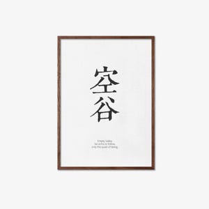 May include: A framed print featuring Japanese calligraphy in black ink on a white background. The artwork includes the characters for "Empty Valley" and the English text "No echo to follow, only the quiet of being."