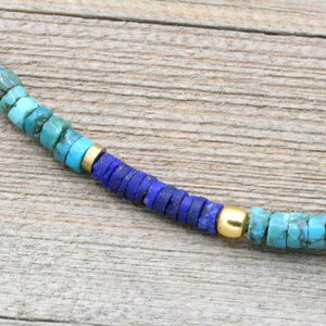 Puede incluir: Un collar de cuentas de turquesa y lapisl&aacute;zuli con detalles dorados. El collar est&aacute; hecho de peque&ntilde;as cuentas redondas y tiene un degradado de color, comenzando con turquesa y pasando a lapisl&aacute;zuli.