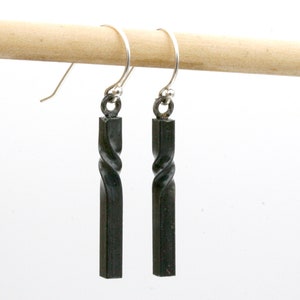 May include: A pair of silver dangle earrings with black twisted metal pendants.