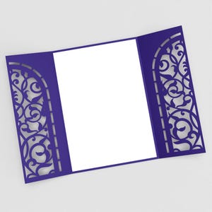 May include: A royal blue invitation card with a decorative, laser-cut design. The card is open, revealing a blank white space for text. The intricate pattern on the sides adds an elegant touch, suitable for weddings or special events.