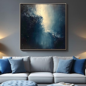 May include: A light gray sofa with blue throw pillows sits in a room with a blue and white abstract painting on the wall. Two blue tufted ottomans are in front of the sofa.