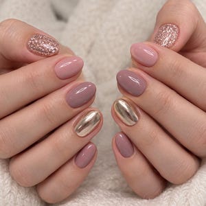 May include: Manicured fingernails featuring a mix of finishes including solid light pink, solid mauve, rose gold glitter, and reflective metallic rose gold chrome polish on oval-shaped nails, showcasing a clean and polished appearance.