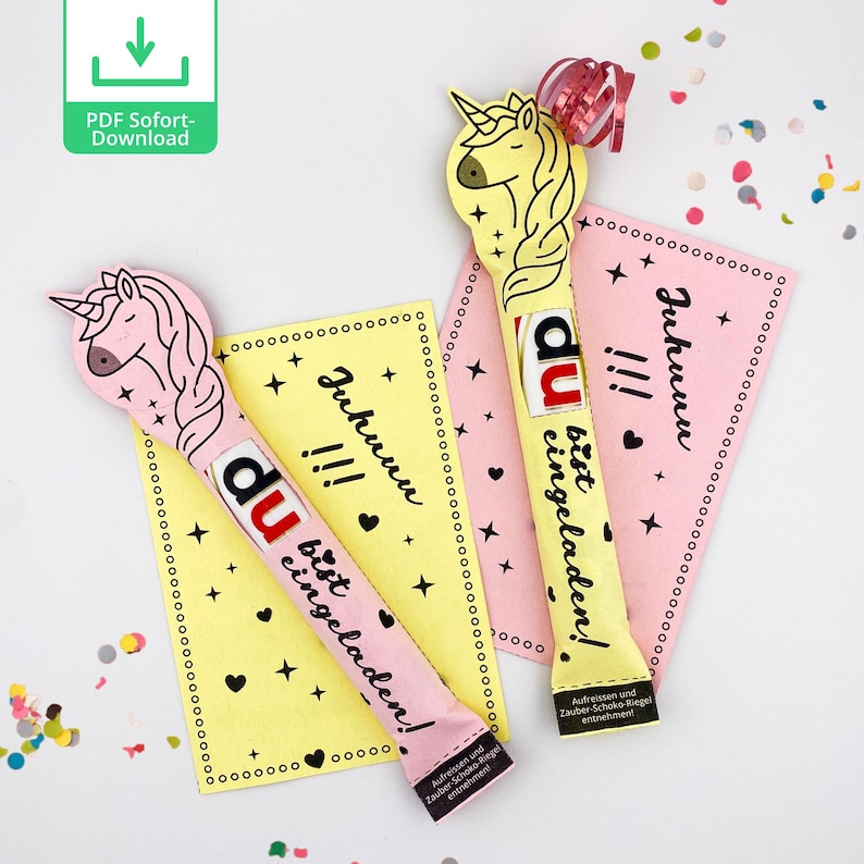 May include: Two pink and yellow unicorn-shaped chocolate bar wrappers with the text "Juhunu!!! Du bist eingeladen!"  The wrappers are decorated with stars and hearts.