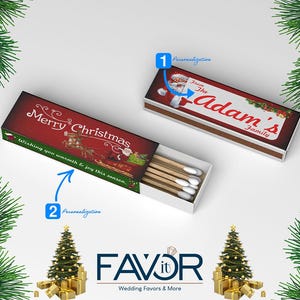 以下が含まれることがあります： クリスマスをテーマにした長方形のマッチ箱が2つ。1つの箱には、トナカイとサンタクロースのイラストとともに「Merry Christmas」と書かれています。もう1つの箱は「The Adam's Family」とパーソナライズされています。箱は開いており、マッチが見えています。