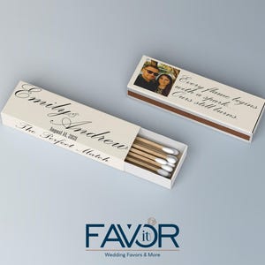 May include: Two rectangular matchboxes with custom text and a photo. One box is open, revealing matches with white tips. The text on the boxes reads "Emily & Andrew, August 14, 2023, The Perfect Match" and "Every flame begins with a spark... Ours still burns."