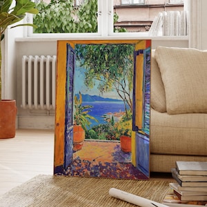 May include: A painting of a doorway with open blue doors leading to a view of a blue ocean and a green hillside. The painting is framed in a yellow frame.