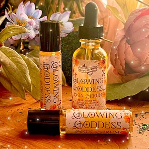 May include: Three glass bottles of glowing goddess skin serum with a yellow and white label. The label features a sunflower and the text "Glowing Goddess Skin Serum".