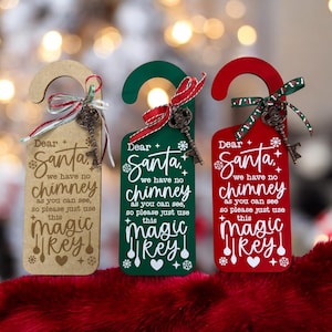 May include: Three Christmas-themed door hangers in beige, green, and red. Each has a decorative key, ribbon, and the text "Dear Santa, we have no chimney, so please just use this magic key!"