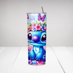 Puede incluir: Un vaso de acero inoxidable azul y blanco con un personaje de dibujos animados que lleva una corona de flores. El personaje est&aacute; rodeado de flores y mariposas. El vaso tiene una pajita.