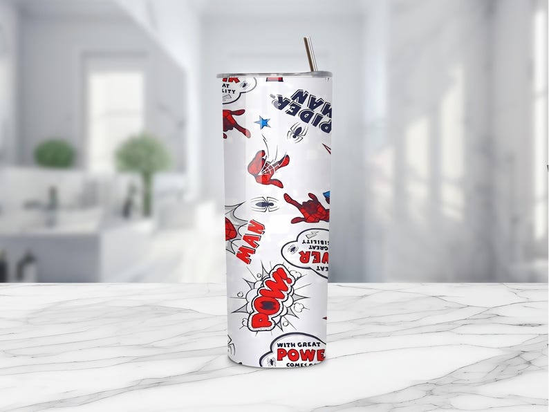 May include: A white tumbler featuring a comic book style design with Spider-Man graphics. The design includes red and blue Spider-Man figures, speech bubbles with words like "POW" and "MAN", and the text "Spider-Man". A stainless steel straw is inserted in the lid.