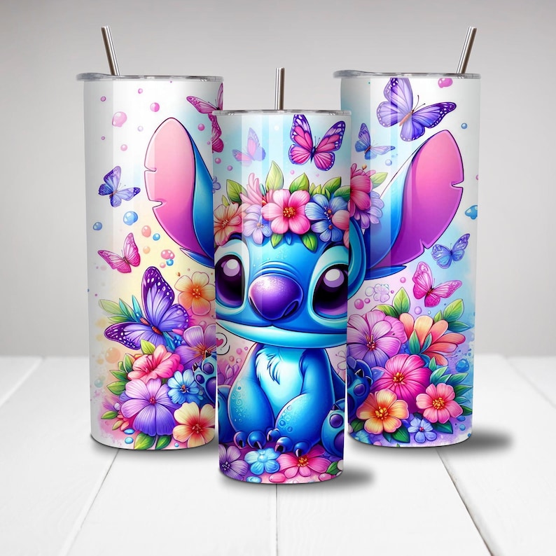 Puede incluir: Un personaje de dibujos animados azul y rosa con una corona de flores, rodeado de mariposas y flores, en un vaso de acero inoxidable blanco.