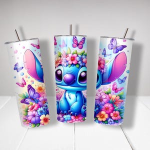 Puede incluir: Tres vasos de acero inoxidable con un personaje de dibujos animados azul con orejas rosas y un dise&ntilde;o floral. El personaje est&aacute; rodeado de mariposas y flores en tonos de rosa, morado y azul.