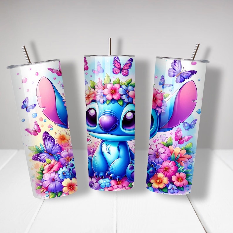 Puede incluir: Tres vasos de acero inoxidable con un personaje de dibujos animados azul con orejas rosas y un dise&ntilde;o floral. El personaje est&aacute; rodeado de mariposas y flores en tonos de rosa, morado y azul.