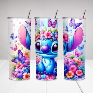 Puede incluir: Un personaje de dibujos animados azul y morado con una corona de flores en un vaso blanco con un dise&ntilde;o floral. El vaso tiene una pajita.