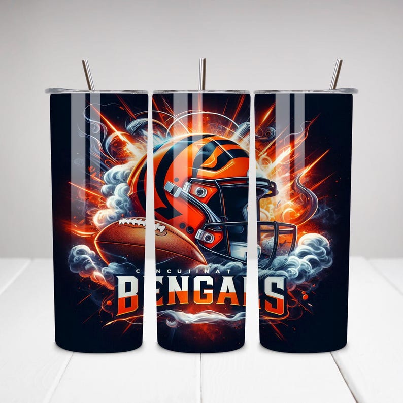 Op de afbeelding: Drie roestvrijstalen bekers met een ontwerp met een voetbalhelm en de woorden "Cincinnati Bengals". Het ontwerp is in oranje, zwart en wit met een rokerige achtergrond.