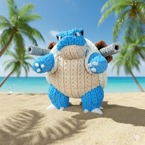Puede incluir: Figura de Blastoise tejida en azul y crema sobre una playa de arena. La figura tiene dos cañones en la espalda. El fondo presenta palmeras y el océano. Detalles azules y blancos.
