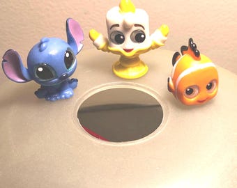Disney Doorables, tiny collectable figurines. Listed are Lemiere, Stitch and Nemo
