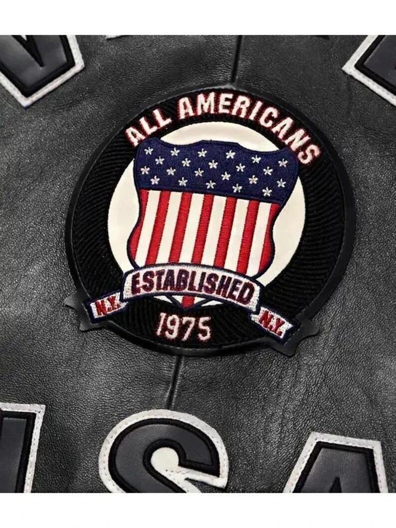 May include: Close-up of a black leather jacket with a circular patch. The patch features a shield design with the American flag and the words "ALL AMERICANS ESTABLISHED 1975 N.Y." in a circular design. Other patches are visible.