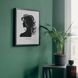 以下が含まれることがあります： 緑色の壁に額縁に入った、黒と白のシルエットのドリー・パートン。黒いサイドテーブルの上に鉢植えの植物が置かれている。