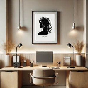 以下が含まれることがあります： 木製の机、2つの黒いランプ、コンピューターモニター、椅子、そしてドリー・パートンのシルエットの白黒の額装されたプリントがある、自宅のオフィスワークスペース。