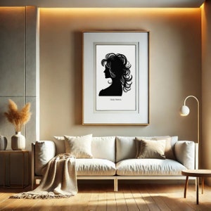 以下が含まれることがあります： ベージュの壁に、金色の額縁に入った、白黒のシルエットで描かれたドリー・パートンのプリントが飾られています。プリントの下には、白いソファと毛布が置かれています。部屋は、金色のフロアランプとサイドテーブルのあるモダンなデザインです。