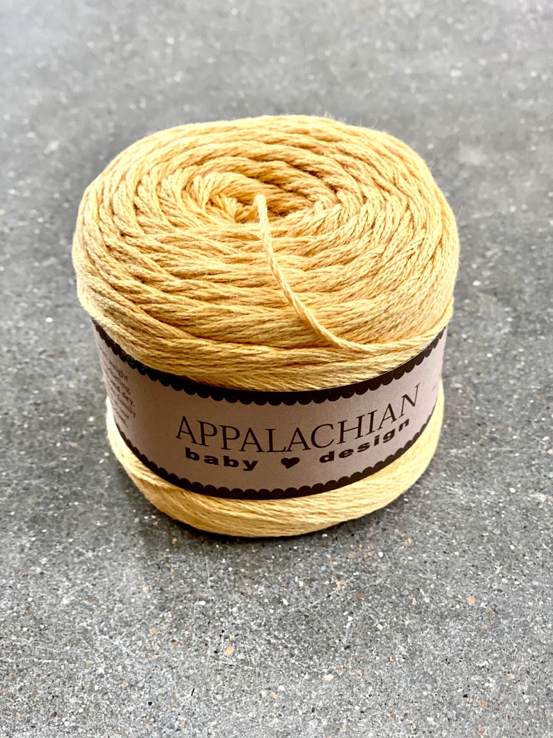 May include: A skein of yellow cotton yarn with a brown label that reads "Appalachian Baby Design".