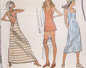 Könnte beinhalten: Vintage Schnittmuster mit drei Kleiderdesigns. Die Designs umfassen ein gestreiftes Maxikleid, ein kurzes orangefarbenes Kleid und ein blaues Midikleid. Das Muster enthält den Text "THE YARDAGE SHOP" und "NO EXCLUSI OR REFUND".
