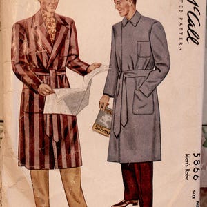 Könnte beinhalten: Vintage McCall's Schnittmuster für einen Herren-Bademantel, mit zwei Illustrationen. Ein Bademantel ist rot und braun gestreift, der andere ist einfarbig grau mit Gürtel. Die Modellnummer ist 5866, Größe Medium, 38-40, und 114 cm.