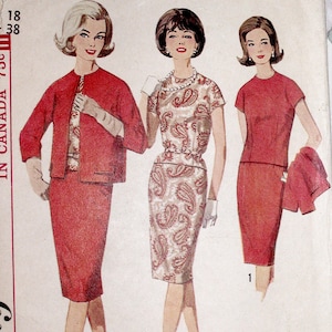 May include: A vintage sewing pattern envelope illustration featuring three outfits: a red skirt suit with a patterned top, a paisley print dress with a belt, and a solid red dress with a matching jacket. The text includes 18, 38, and Proportioned sizes.