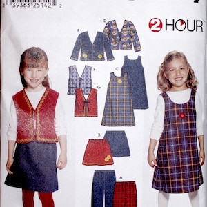 May include: Simplicity sewing pattern featuring children's clothing designs. The pattern includes options for dresses, skirts, vests, and jackets. The image shows a variety of styles, including plaid and solid fabrics, with sizes ranging from 2 to 6X.