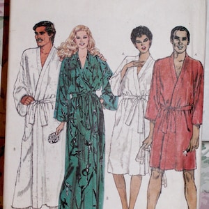 Könnte beinhalten: Vintage Vogue Schnittmuster mit Illustrationen von vier Personen in Bademänteln. Das Schnittmuster ist in der Größe X-Large. Die Bademäntel sind in Weiß, Grün und Rot. Das Vogue-Logo befindet sich oben.