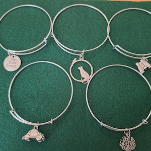 Pulsera rígida apilable con dijes para mujer, plateada y brillante.