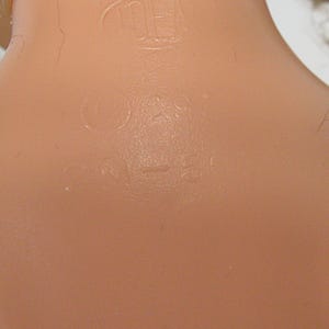 May include: A light peach-colored plastic surface featuring embossed text and markings. The text includes the word IDEAL enclosed in an oval shape, followed by the copyright symbol, the number 29, and the alphanumeric code PN-50, all molded into the material.