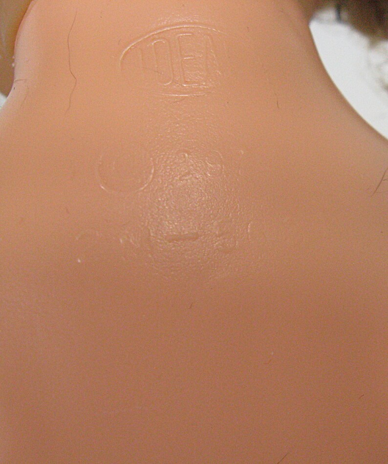 May include: A light peach-colored plastic surface featuring embossed text and markings. The text includes the word IDEAL enclosed in an oval shape, followed by the copyright symbol, the number 29, and the alphanumeric code PN-50, all molded into the material.