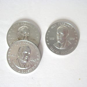 May include: A collection of silver commemorative coins, each bearing a presidential portrait. One coin is inscribed with "20th President" and "Calvin Coolidge", with the years 1923 and 1929. Other coins feature different presidents.