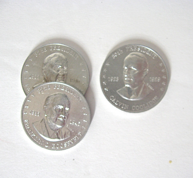 May include: A collection of silver commemorative coins, each bearing a presidential portrait. One coin is inscribed with "20th President" and "Calvin Coolidge", with the years 1923 and 1929. Other coins feature different presidents.