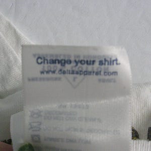 May include: White t-shirt with a blue tag that says "Change your shirt. www.deltasapparel.com"
