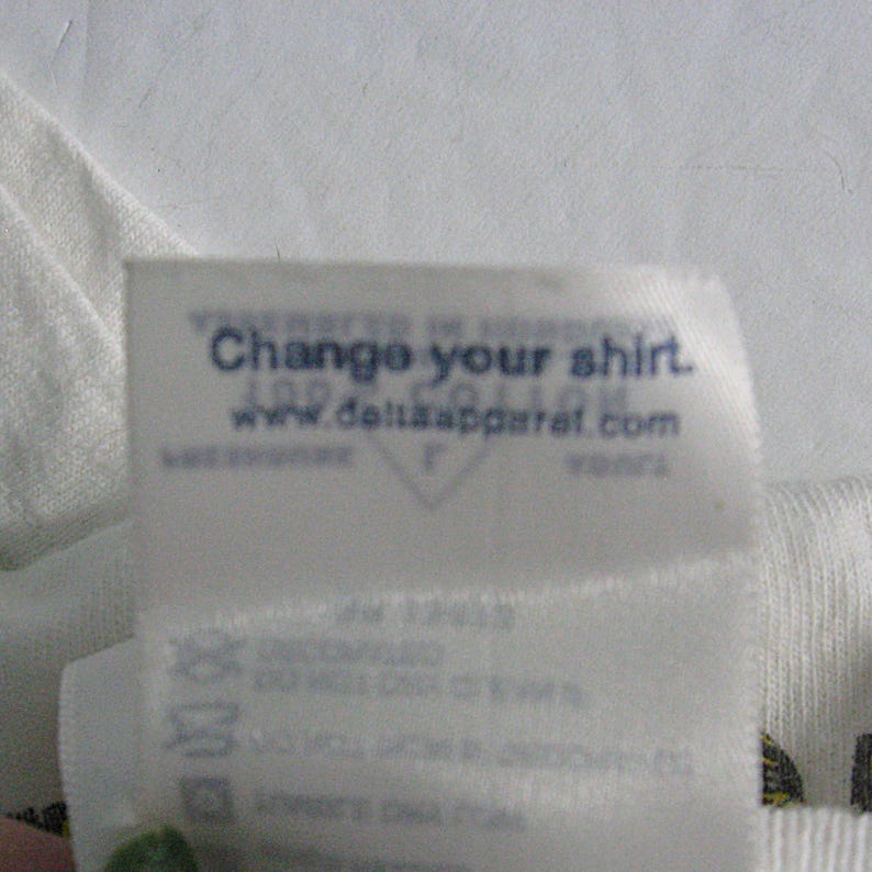 May include: White t-shirt with a blue tag that says "Change your shirt. www.deltasapparel.com"