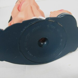 May include: The bottom of a blue plastic figurine base with the text "The Rocket" and "Made in China" printed on it. The base also has the text "&copy; 1994  GT  Interactive  Inc."