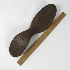 May include: A rusty metal shoe last, approximately 10 inches long, used for shaping shoes.