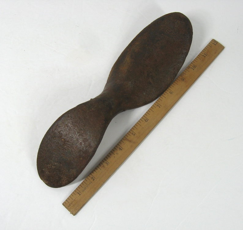 May include: A rusty metal shoe last, approximately 10 inches long, used for shaping shoes.