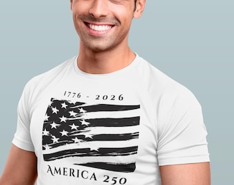 May include: White t-shirt featuring a distressed American flag design with the text "1776 - 2026" and "AMERICA 250" in black. The shirt is worn by a person smiling at the camera.